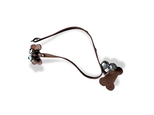 Li’l Pals dog potty training bells hanging on a door, designed to help dogs signal when they need to go outside.